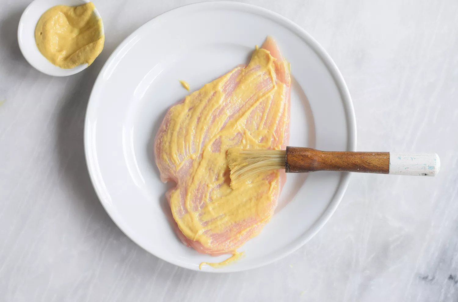 Badigeonner le poulet avec de la moutarde de Dijon