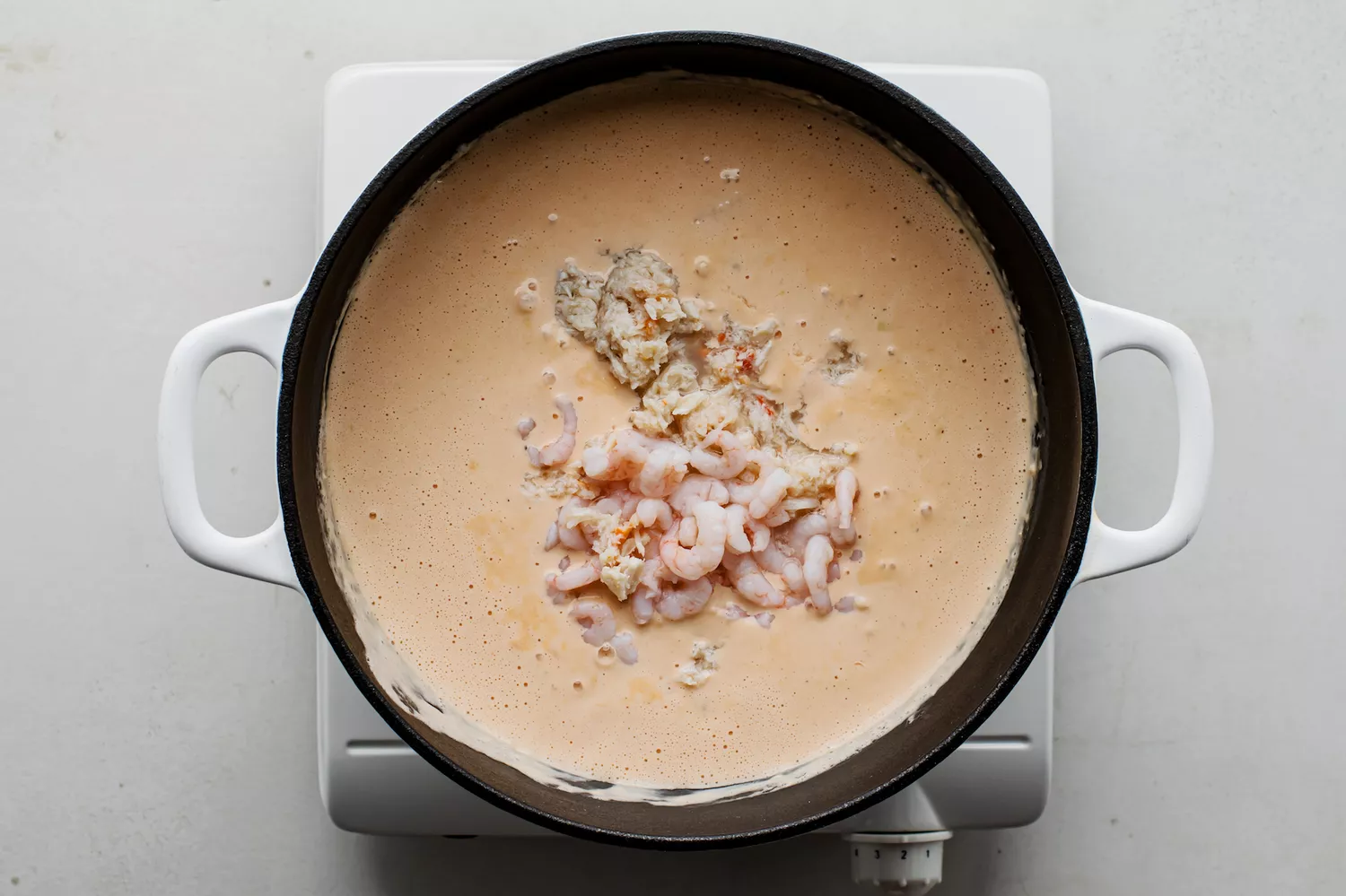Crevettes, crabe et sherry ajoutés à la base de soupe dans une casserole