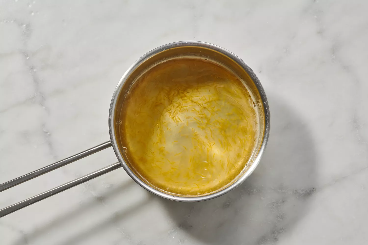 Une casserole de jus de citron, de zeste de citron et de sucre