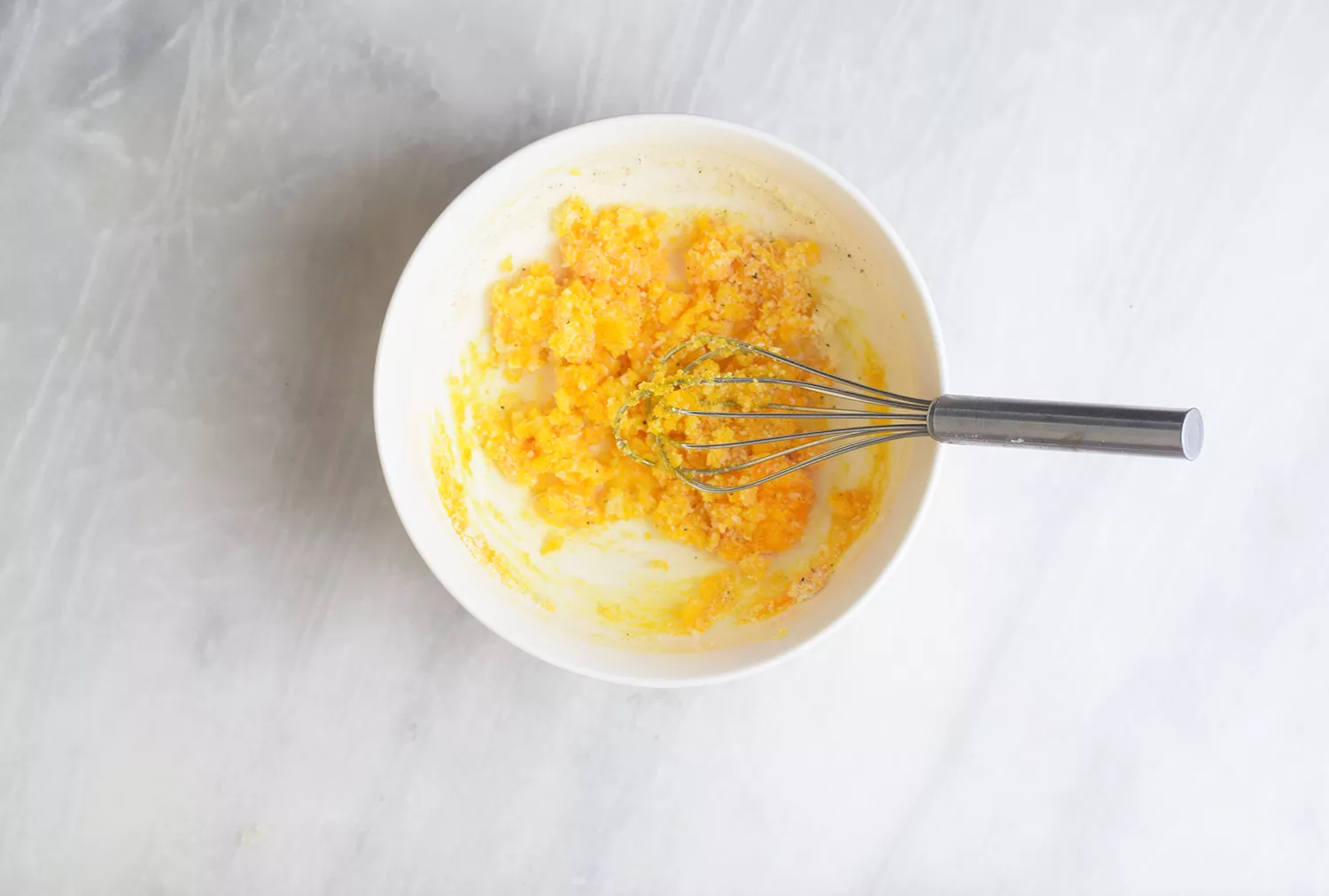 Mélanger l'œuf et le fromage pour Spaghetti Squash Carbonara