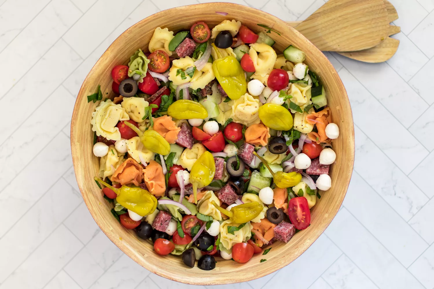 tortellini pasta salad with vegetables, cheese, and salami