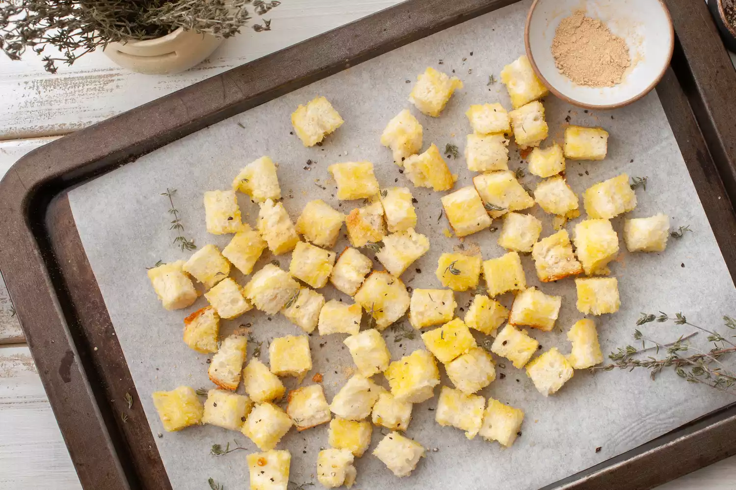 Assaisonnez les croûtons avec des herbes séchées sur une plaque