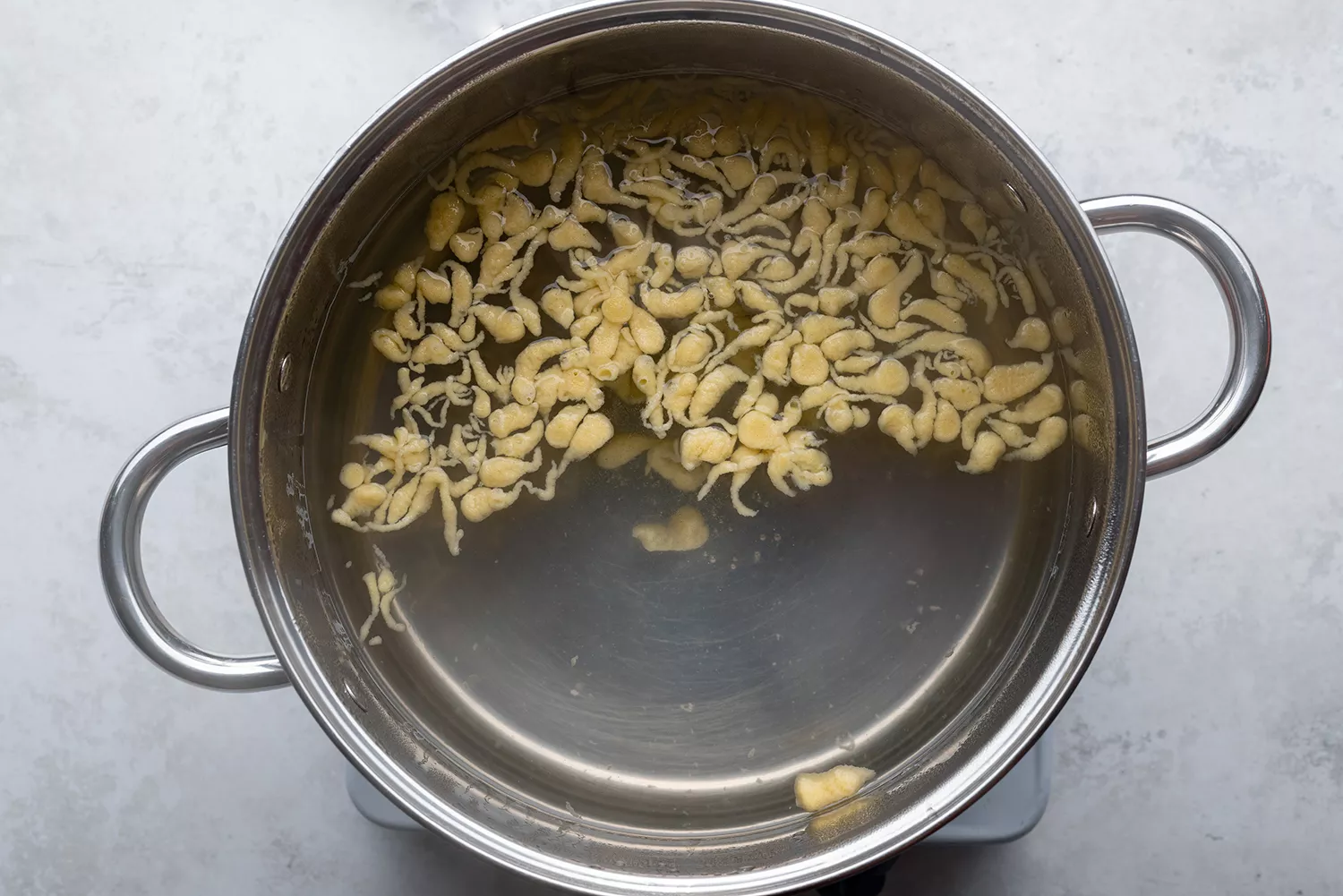 Boulettes de spaetzle en train de cuire dans une casserole