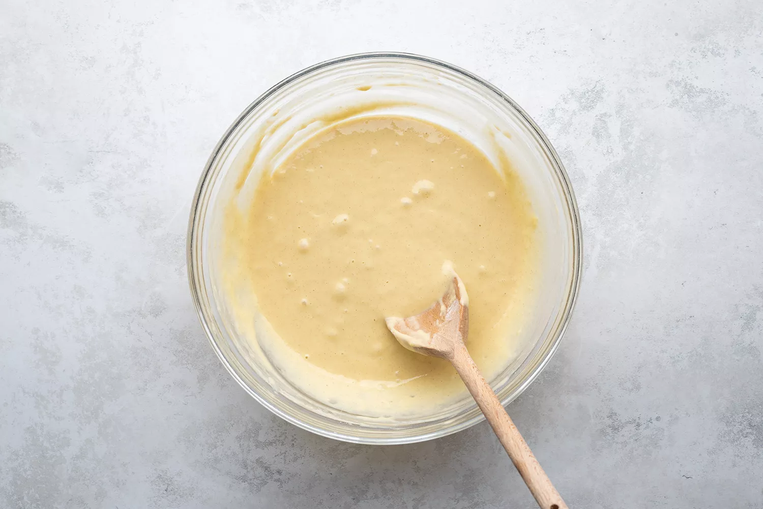 Pâte dans un bol en verre avec une cuillère en bois
