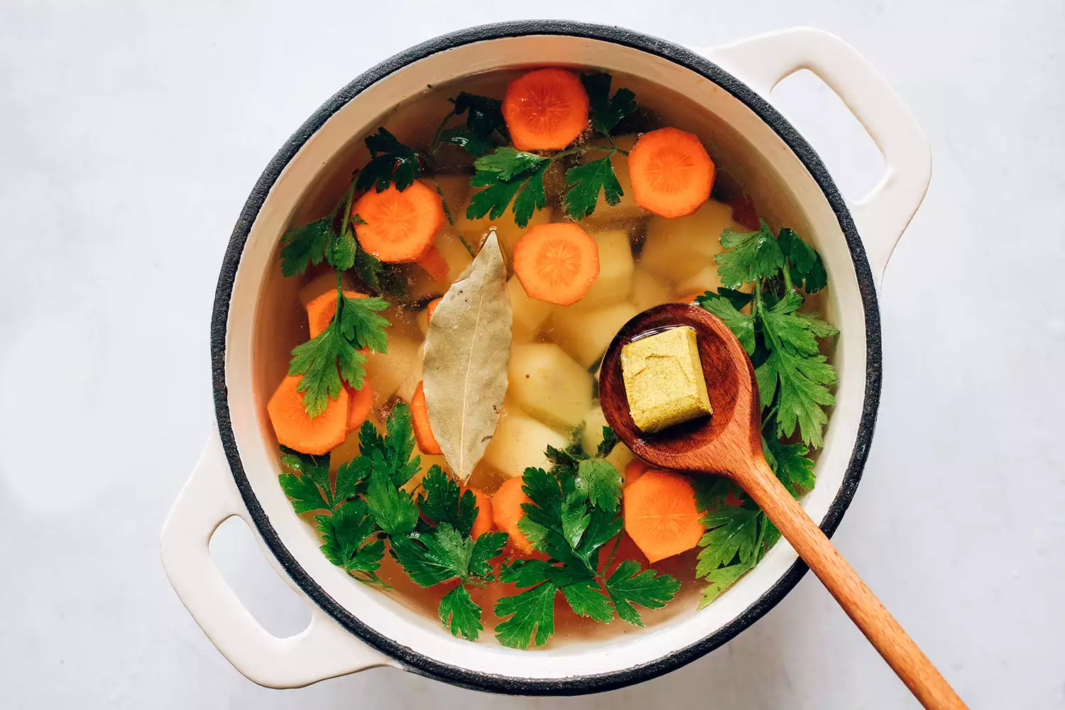 Pommes de terre, cube de bouillon et feuille de laurier dans une casserole