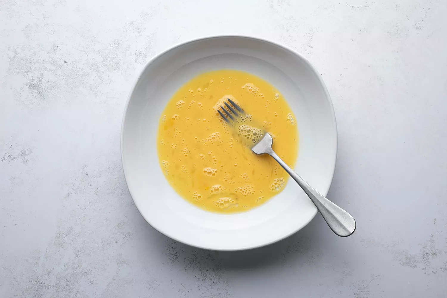 Mélange d'œufs et d'eau dans un bol