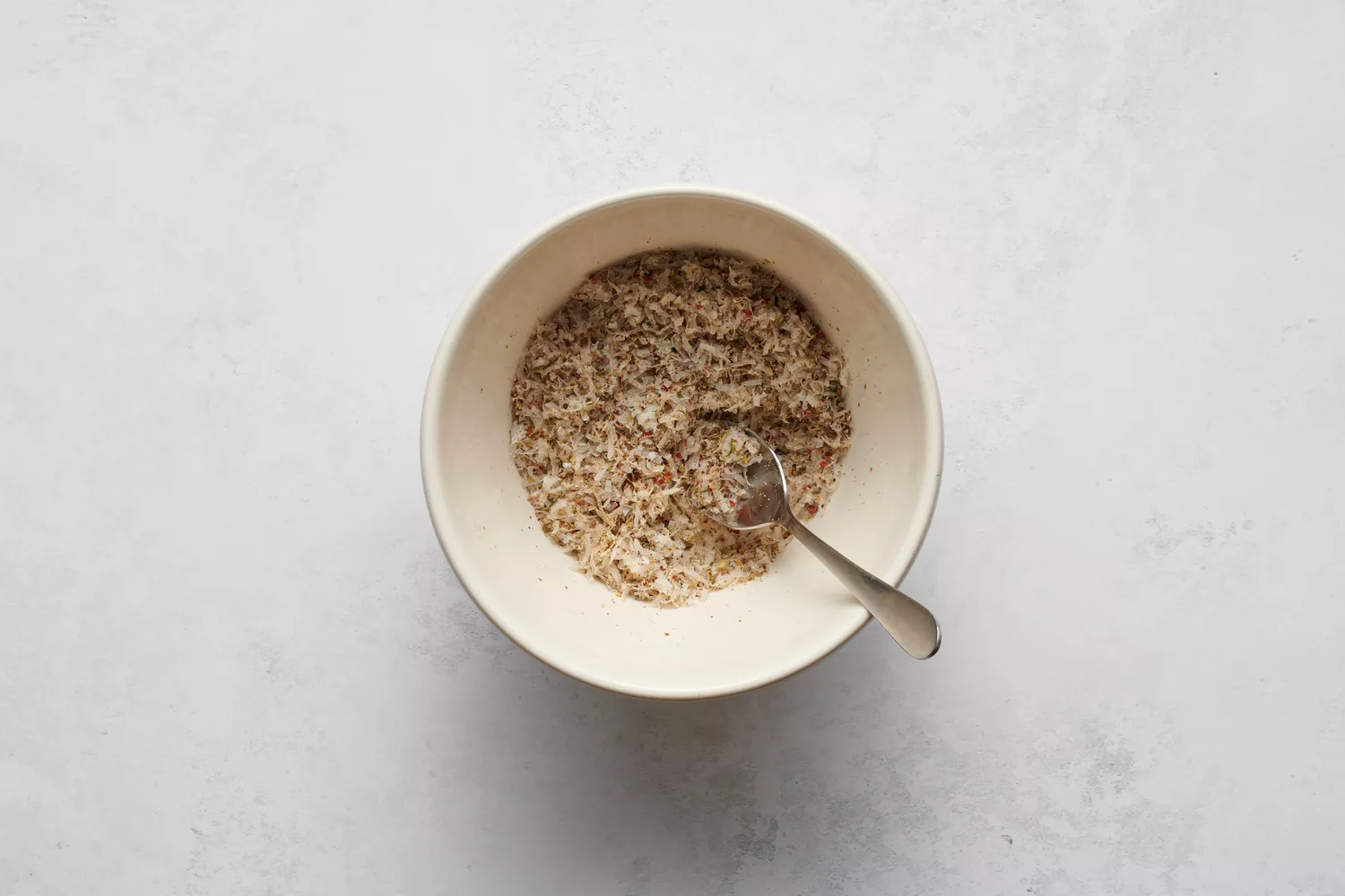 Un petit bol de parmesan, assaisonnement italien, sel de céleri, poudre d'ail et flocons de piment rouge
