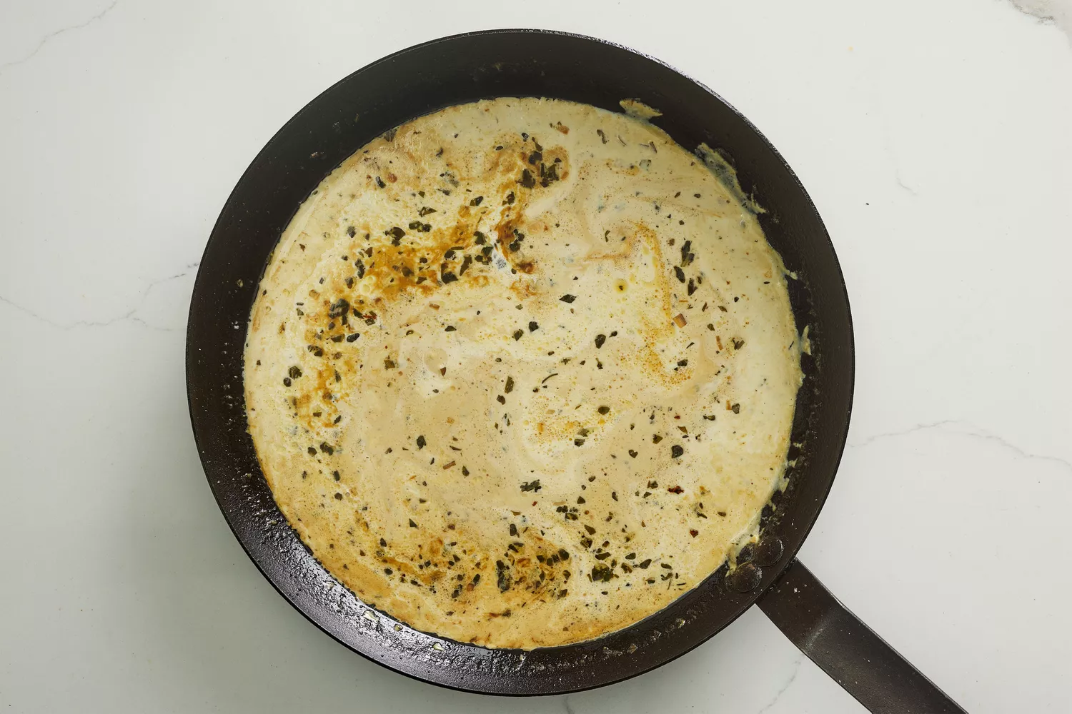 A skillet of creamy dijon mustard sauce